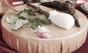 Drum with pink rose, drumstick with soft head, and carved wood on top